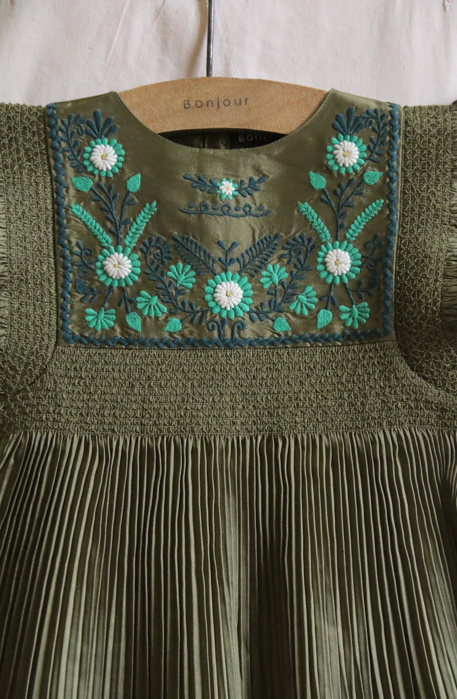 Olive green childrenswear dress with pleated skirt and floral embroidered yoke