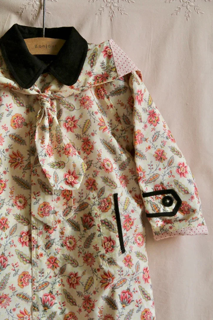Children’s floral print blouse with black collar, front tie, and decorative sleeve detail