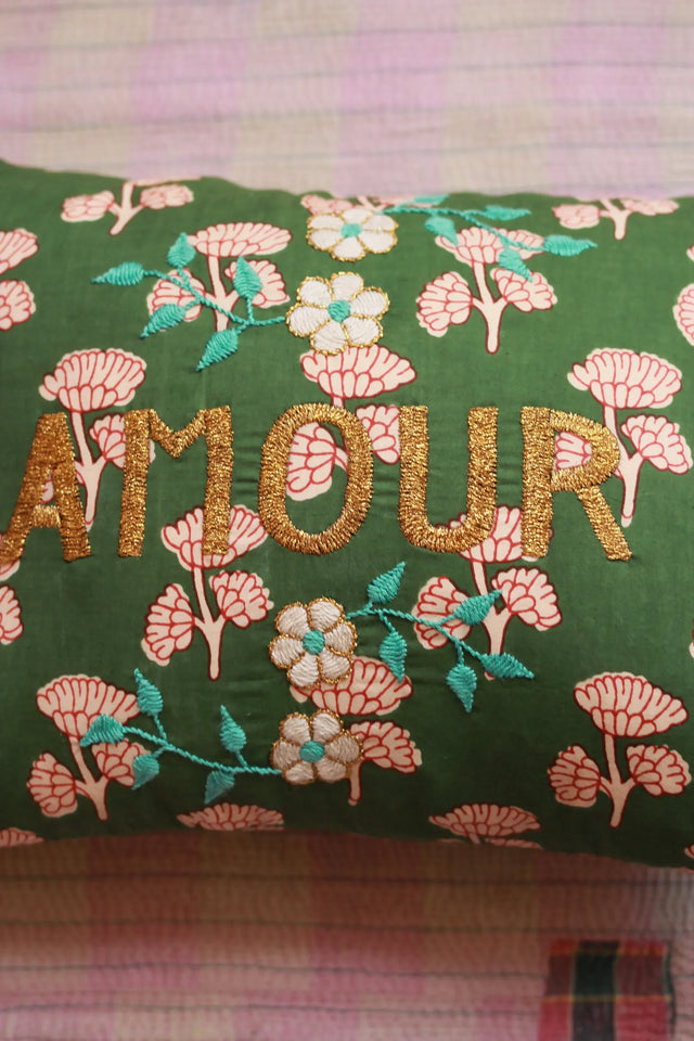 Green floral embroidered cushion with gold 'AMOUR' text and decorative flowers