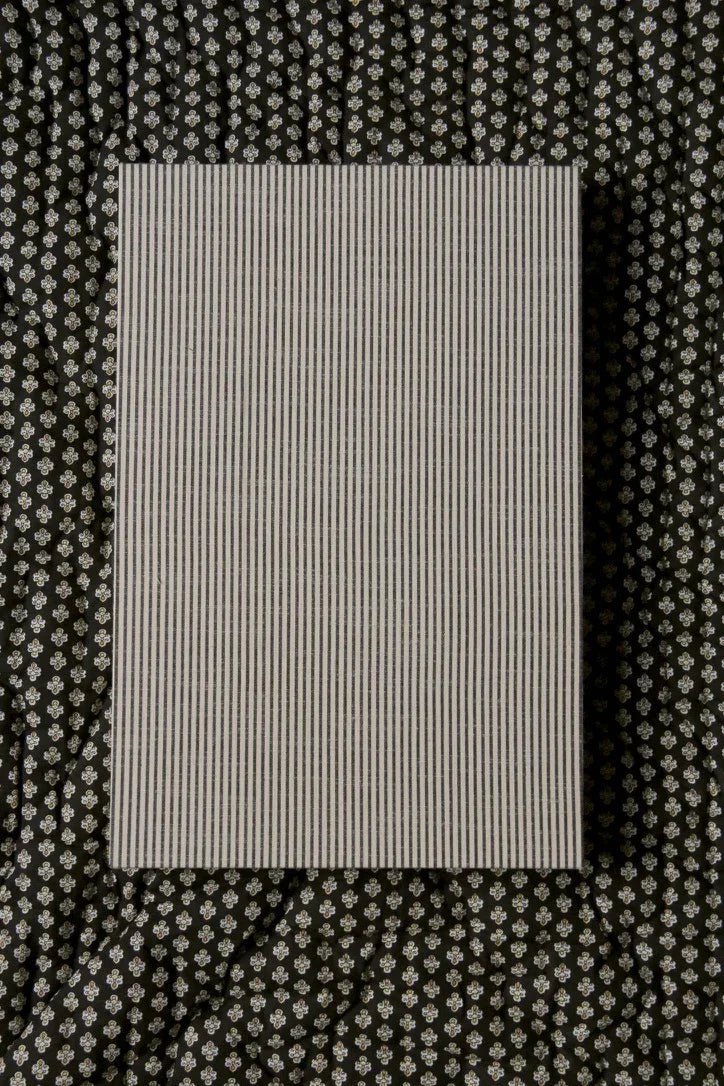 Striped linen fabric sample on floral patterned textile background