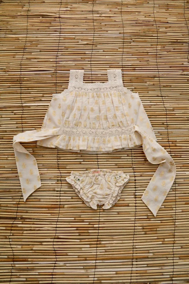 Cream floral printed baby girl top with lace detail and matching ruffle bloomers on bamboo mat
