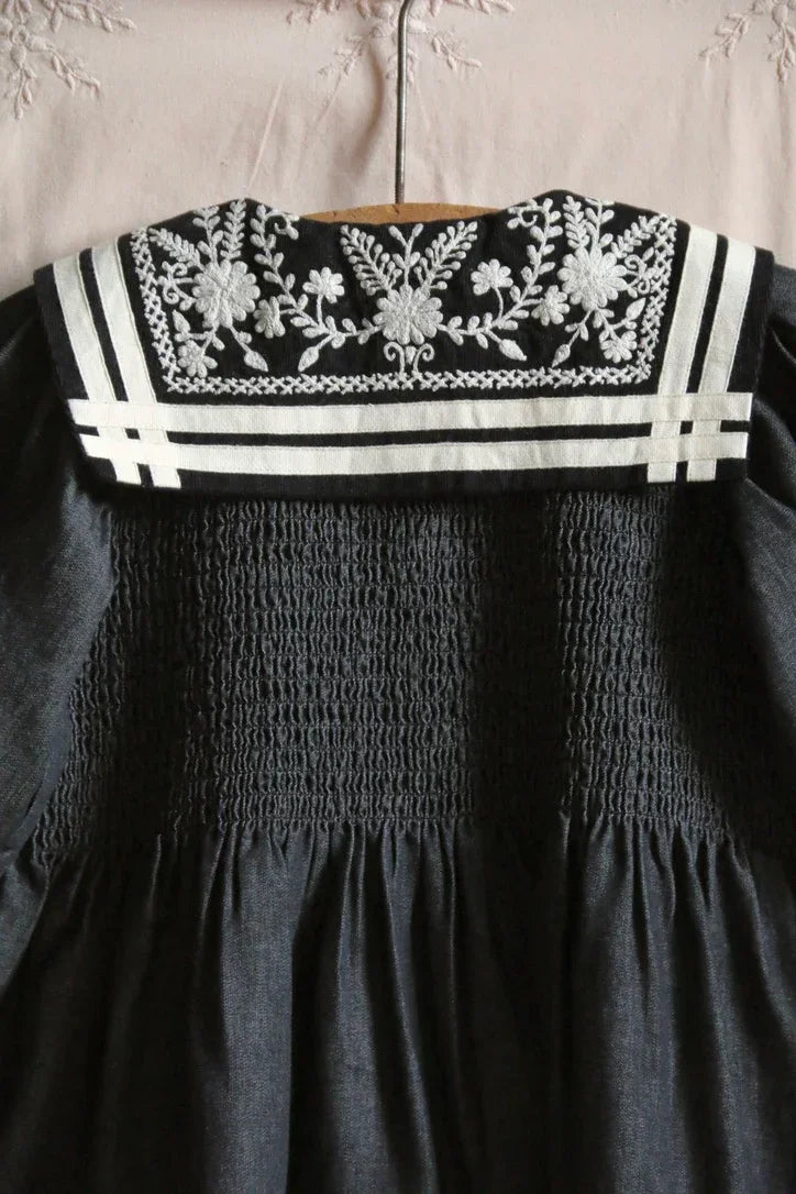 Navy children's dress with white embroidered floral collar and smocked detailing