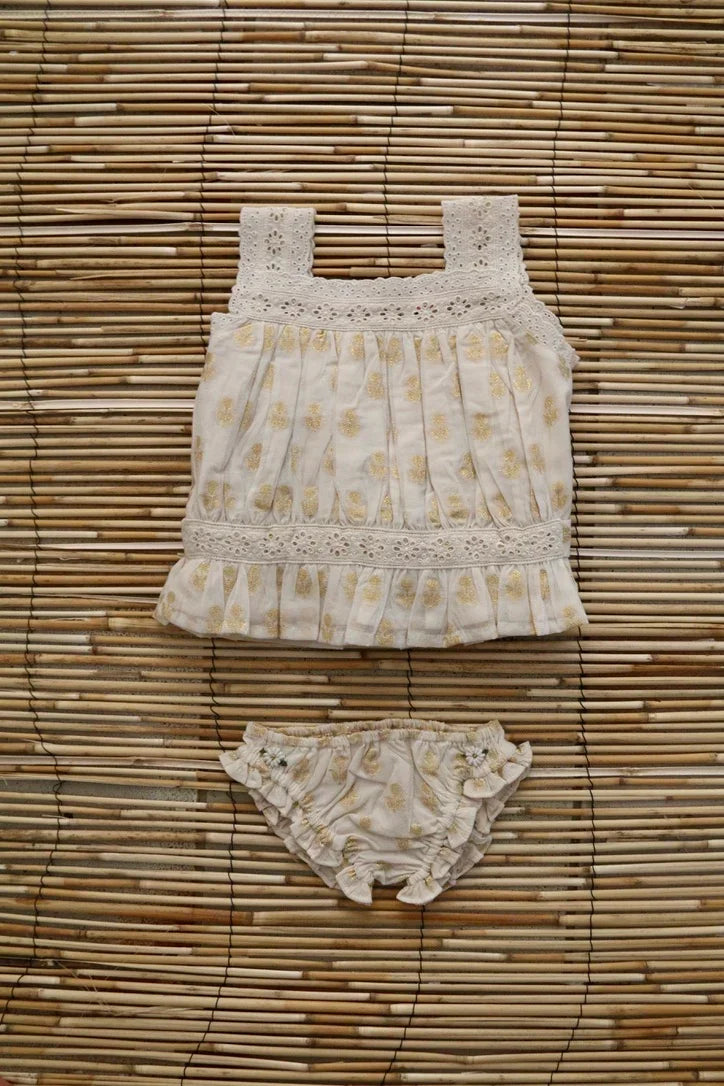 Cream baby top and bloomers with yellow floral print and lace details on bamboo mat