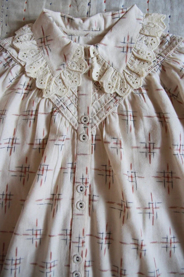 Children’s dress with lace collar, geometric pattern, and button-down front