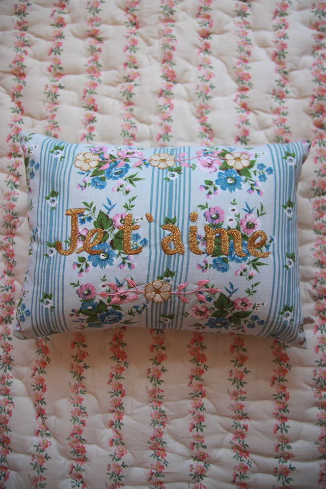 Embroidered floral cushion with Je t'aime text on vintage stripe bedding