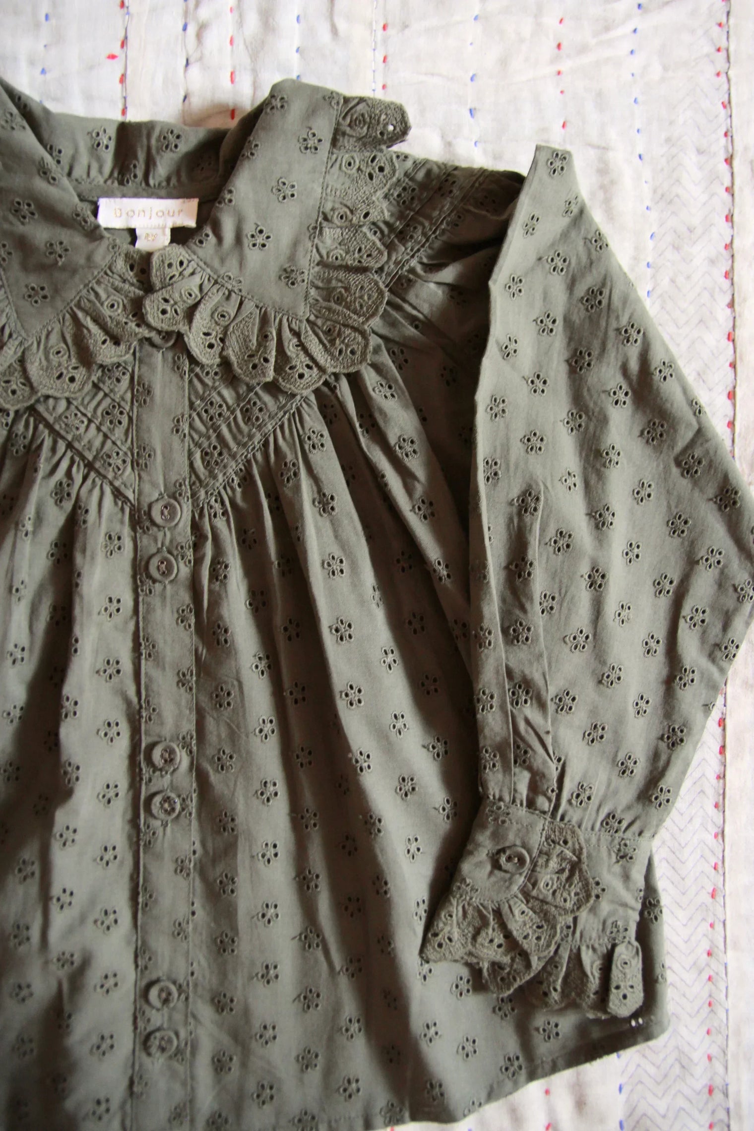 Olive green embroidered cotton blouse with ruffled collar and floral eyelet details