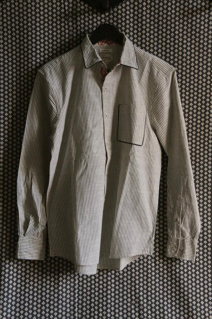 Striped long sleeve cotton shirt with chest pocket hanging on patterned background