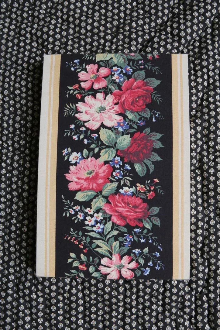 Floral print textile with pink and red flowers on a black patterned fabric background