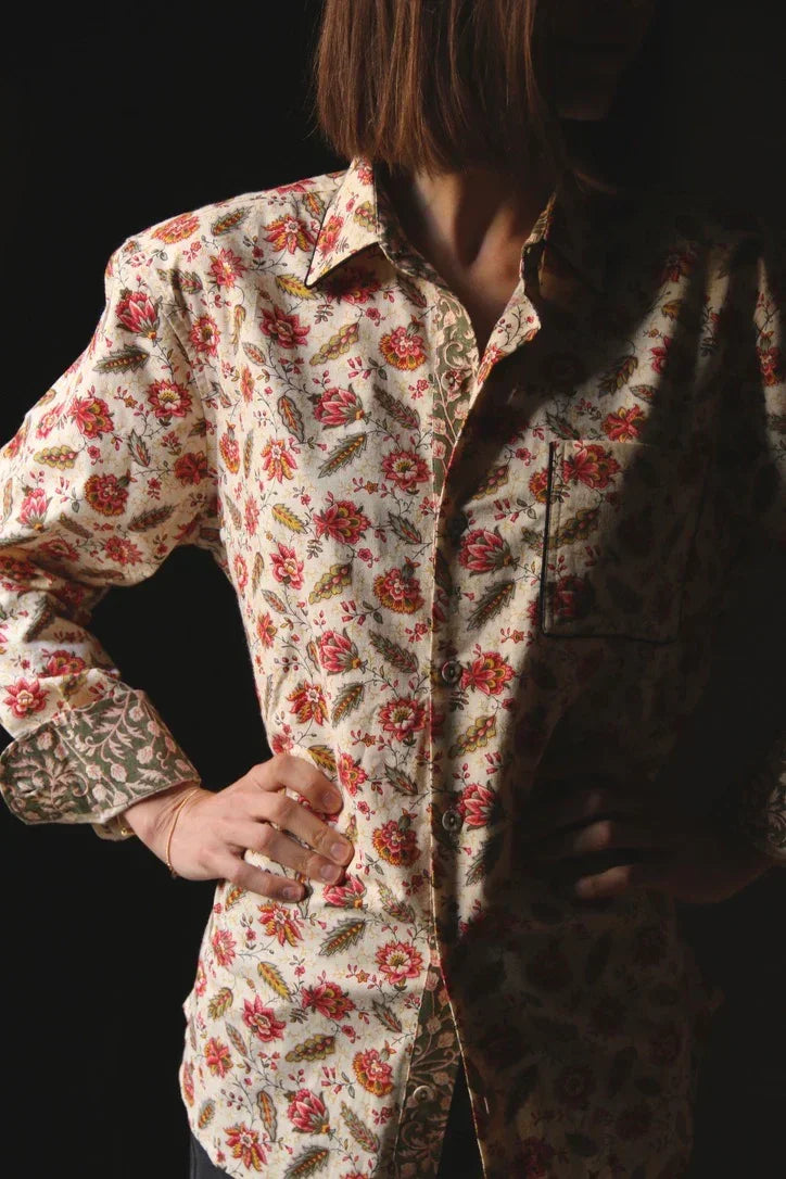 Woman wearing a long-sleeve button-up shirt with colorful floral pattern
