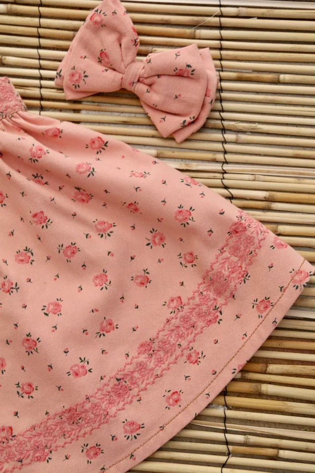 Pink floral cotton skirt and matching bow on bamboo mat, delicate child fashion