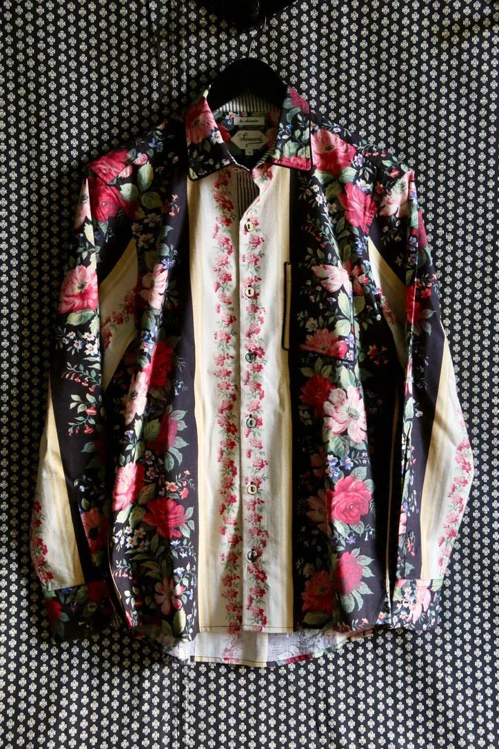 Long-sleeve button-down shirt with floral print and cream stripes, hanging on patterned background