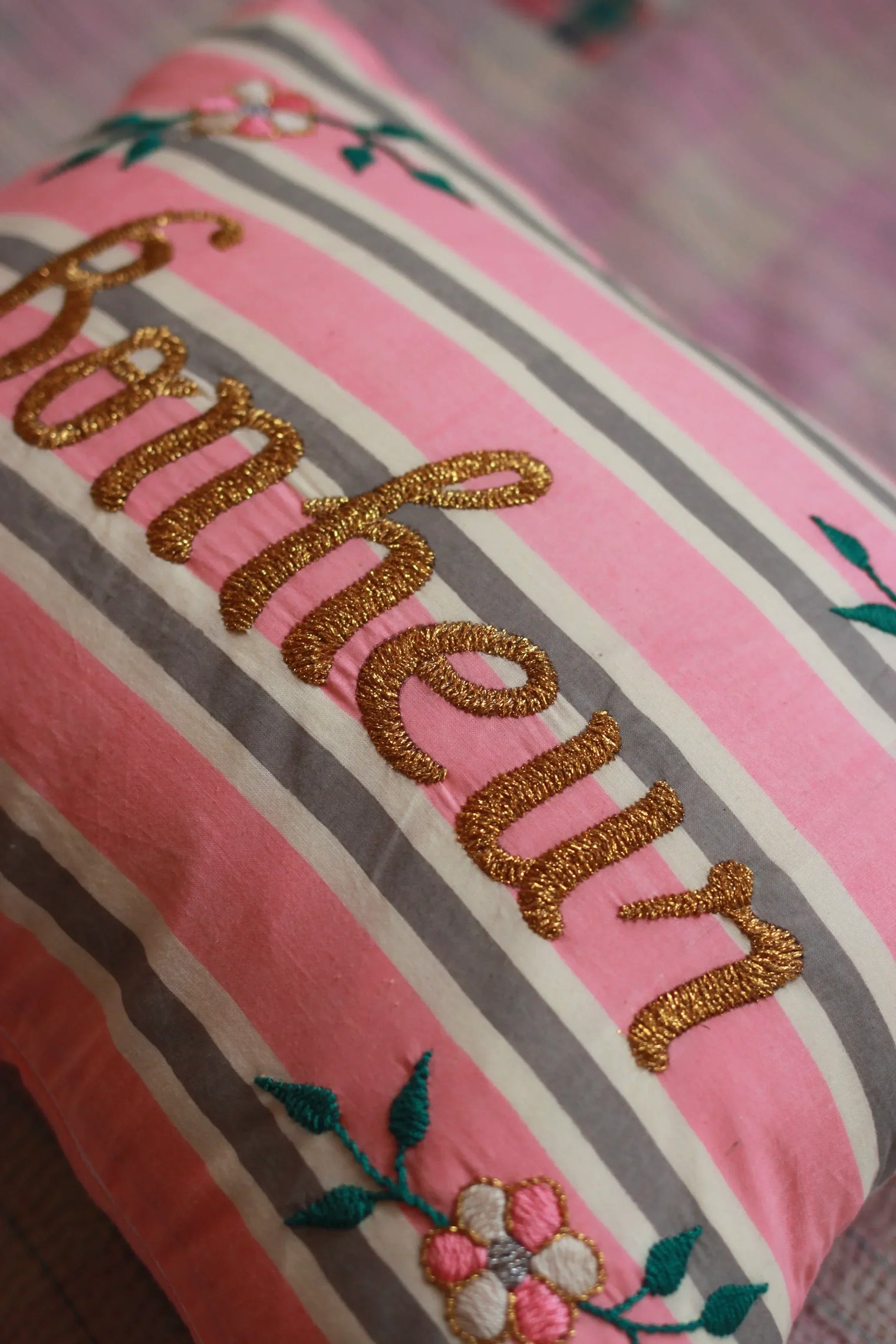 Pink and gray striped pillow with gold embroidery, floral design, decorative home linen.