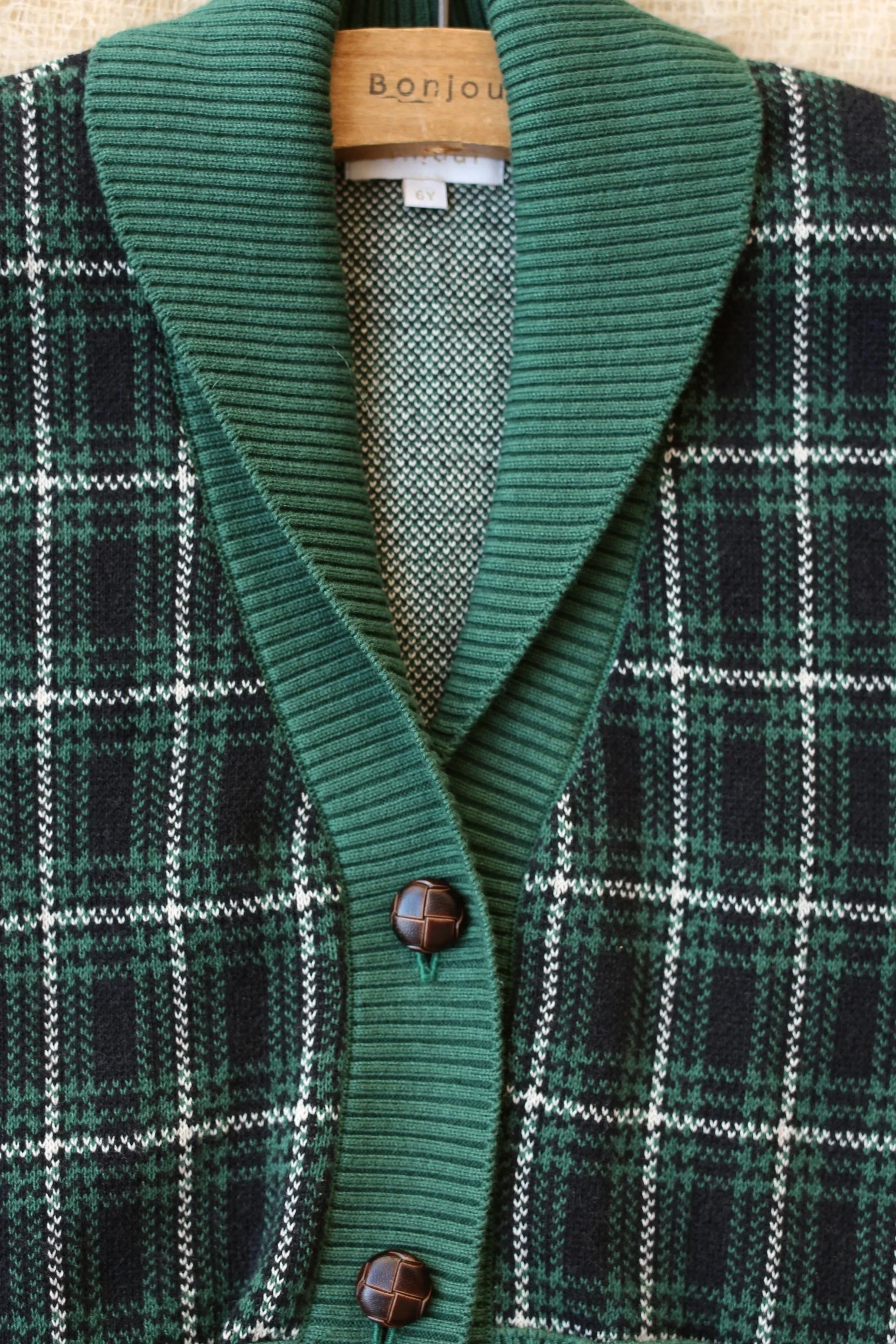 Green plaid knit cardigan with ribbed collar and brown buttons for kids