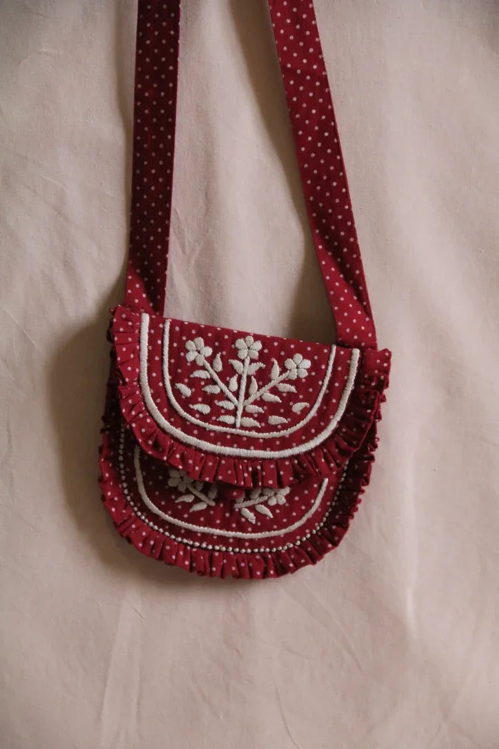 Small embroidered bag with red polka dots and matching hair clip