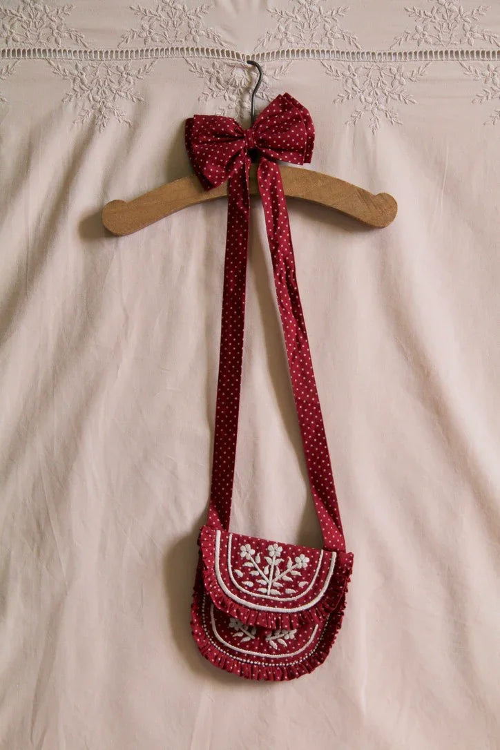 Small embroidered bag with red polka dots and matching hair clip