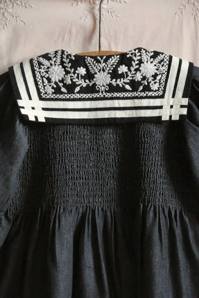 Navy children's dress with white embroidered floral collar and smocked detailing