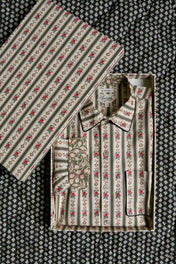 Striped floral print shirt folded in matching decorative box on patterned fabric background