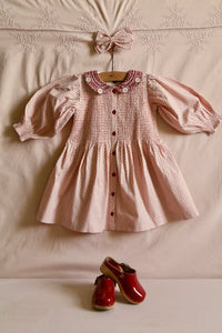 Red polka dot tunic on a pink background with matching hair clip