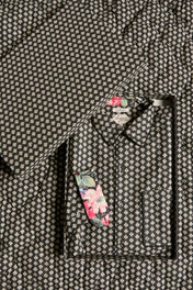 Black floral patterned shirt and eye mask gift set on matching quilted fabric background